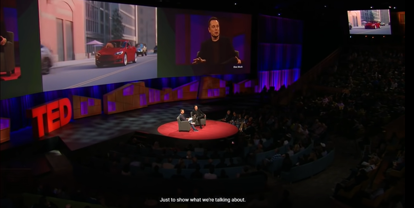 Un TED talk sullo schermo con il sottotitolo di YouTube mostrato in basso.